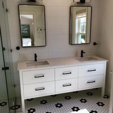 Renovated bathroom — double vanity with black hardware and hex tile floor