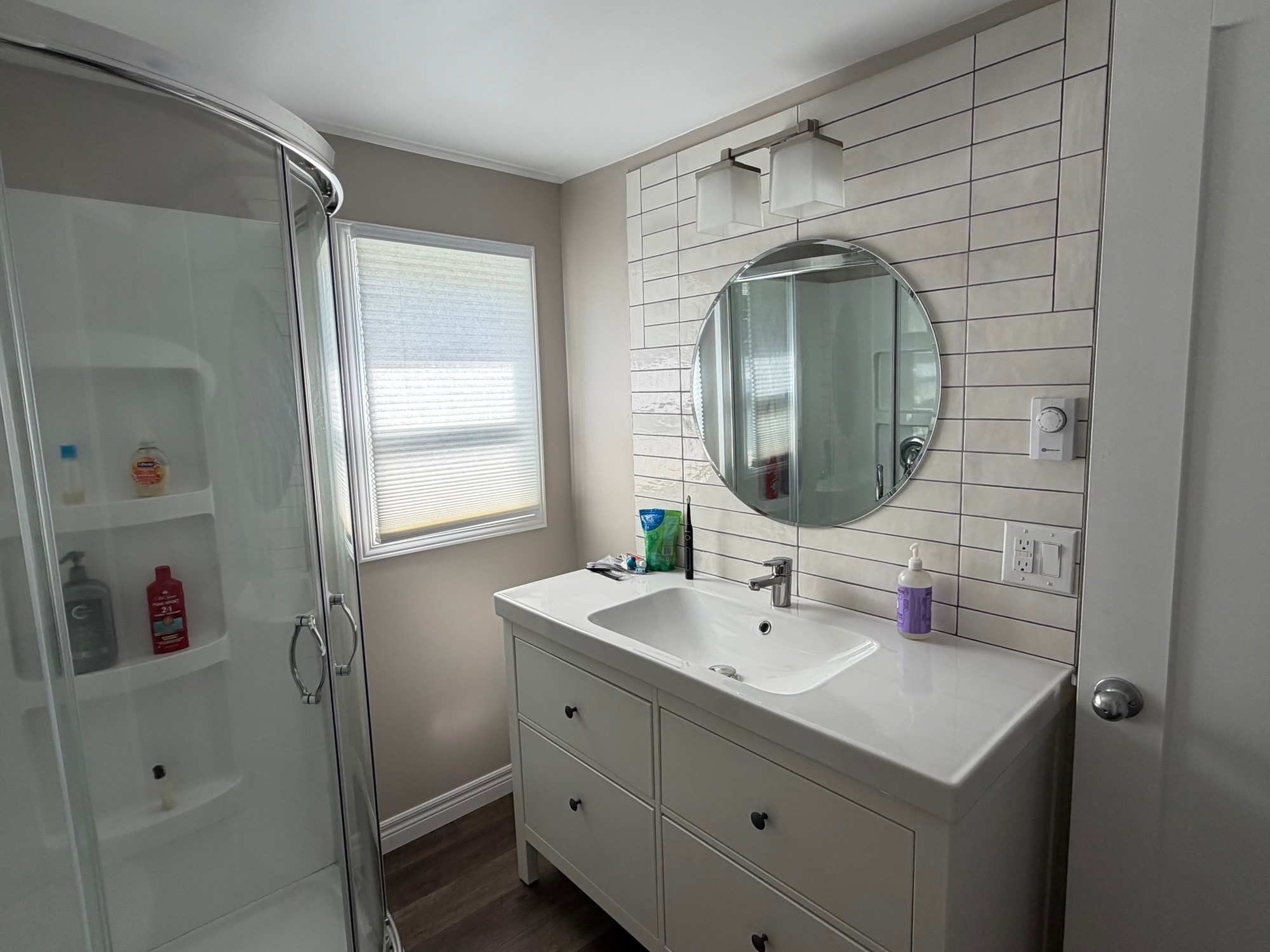 Renovated bathroom with white vanity and shower