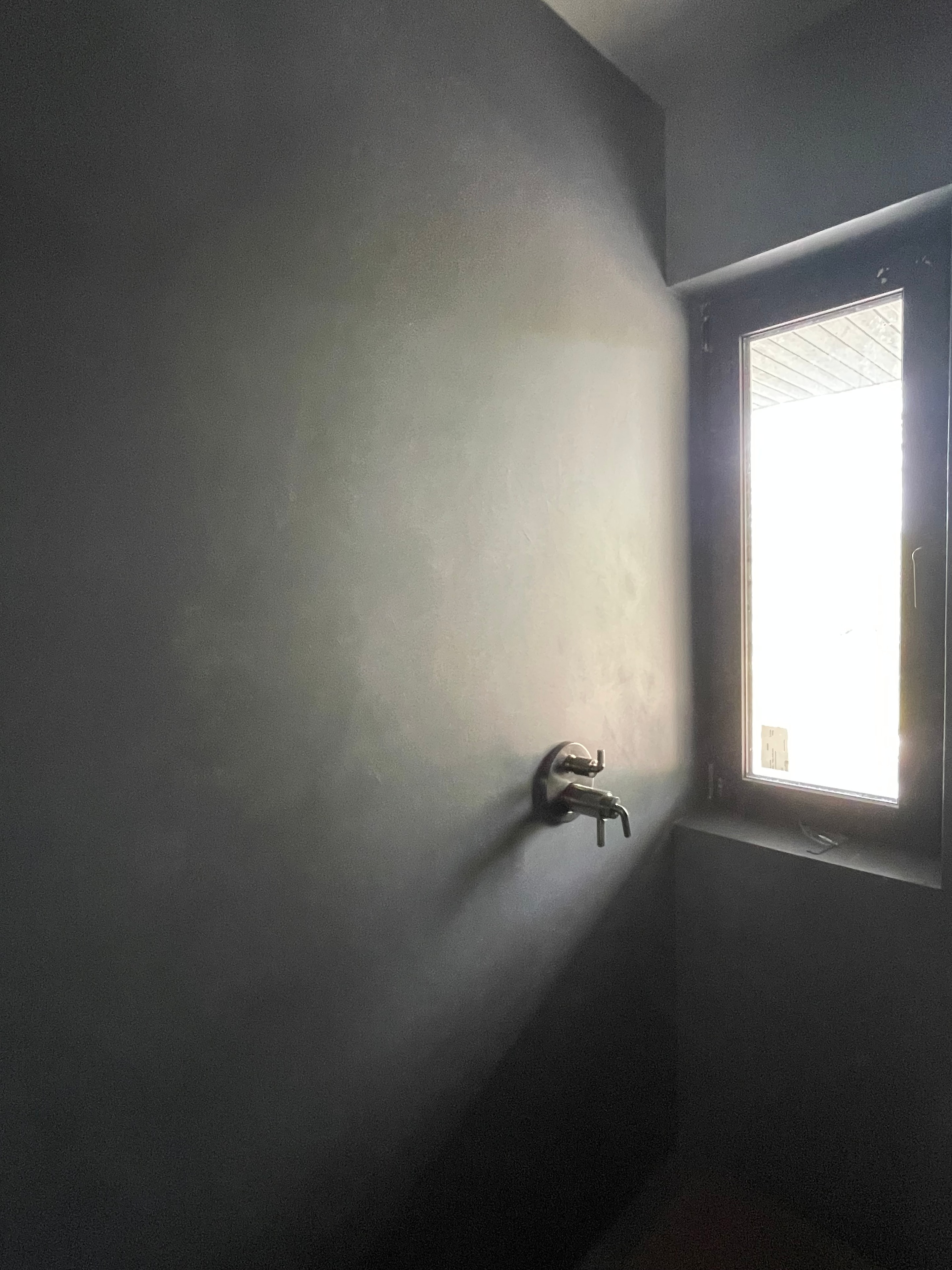 Sunroom addition — polished plaster bathroom with wall-mount faucet and natural light
