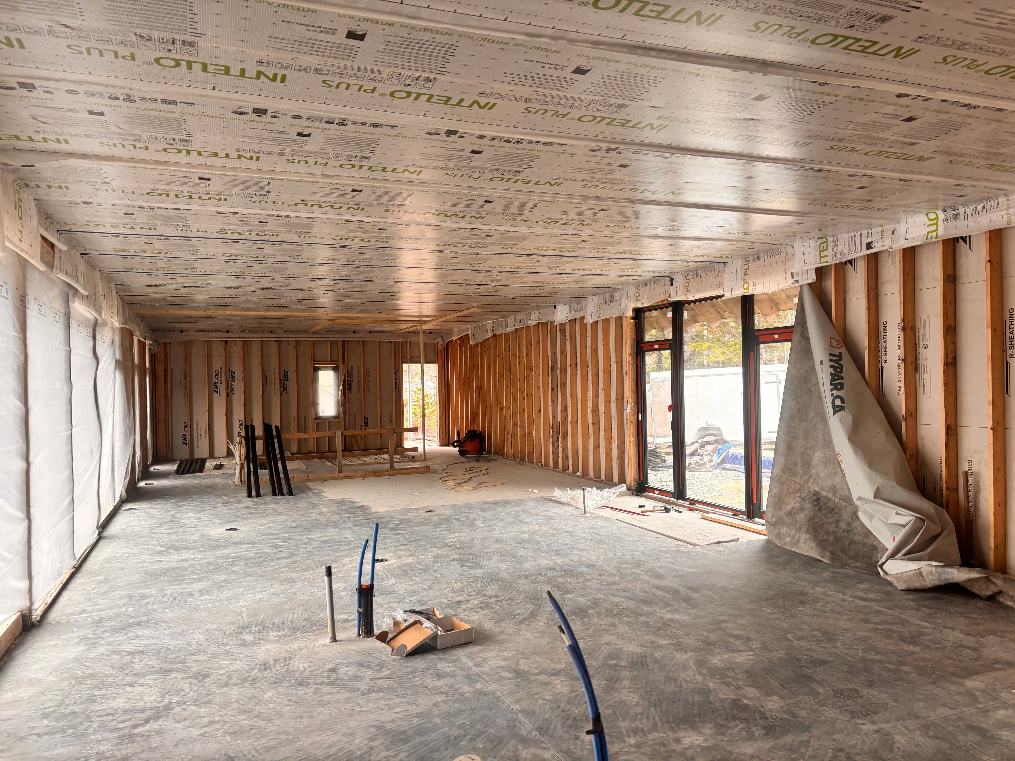 Sunroom addition — open interior framing with vapour barrier ceiling and sliding glass doors