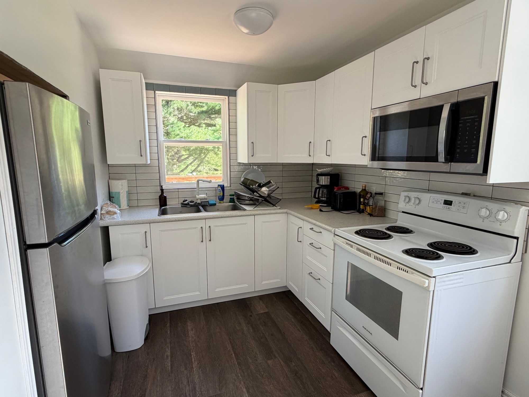 Renovated kitchen with white cabinetry and subway tile