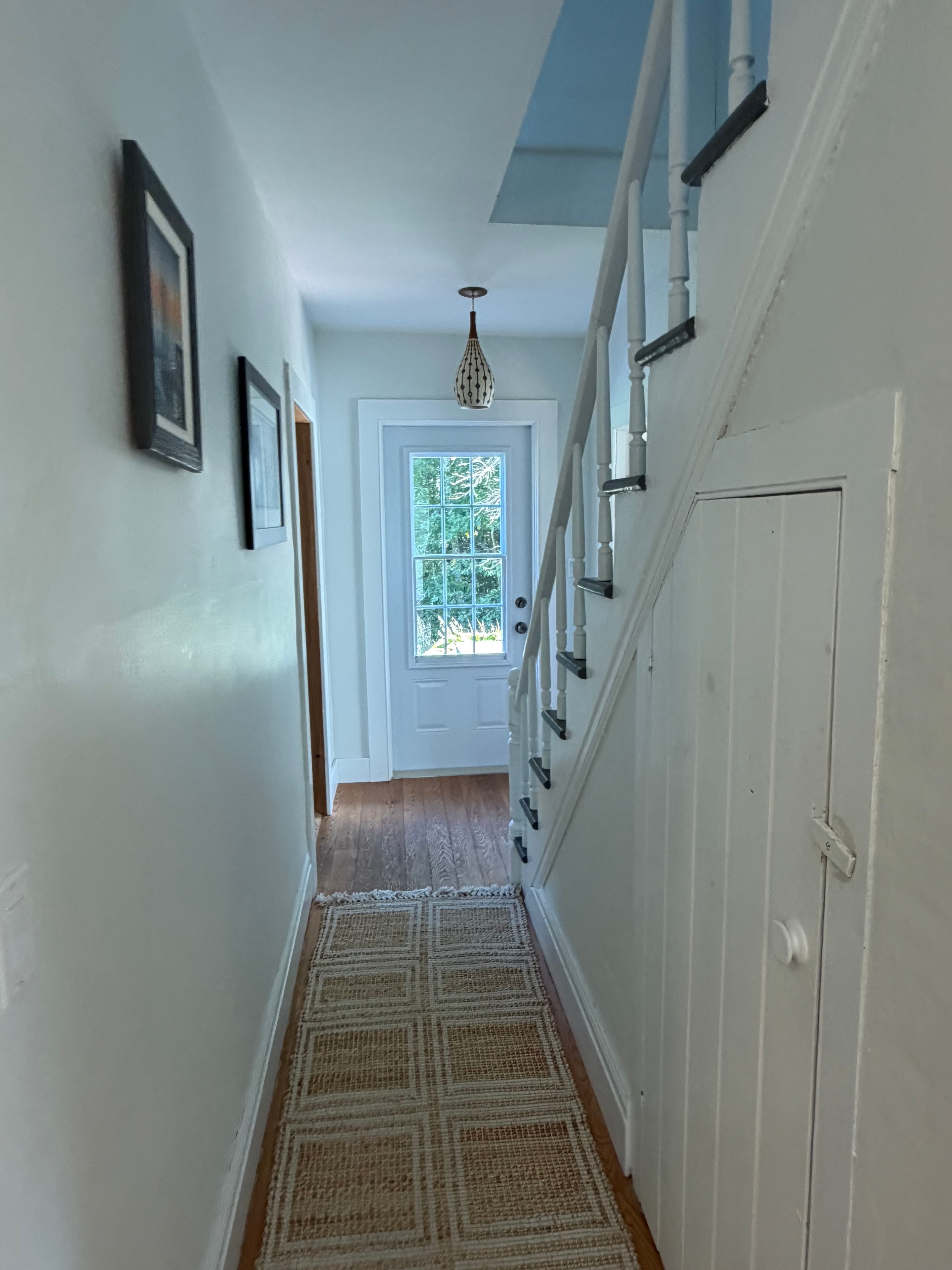 Renovated entryway hallway — bright with pendant light and original hardwood floors