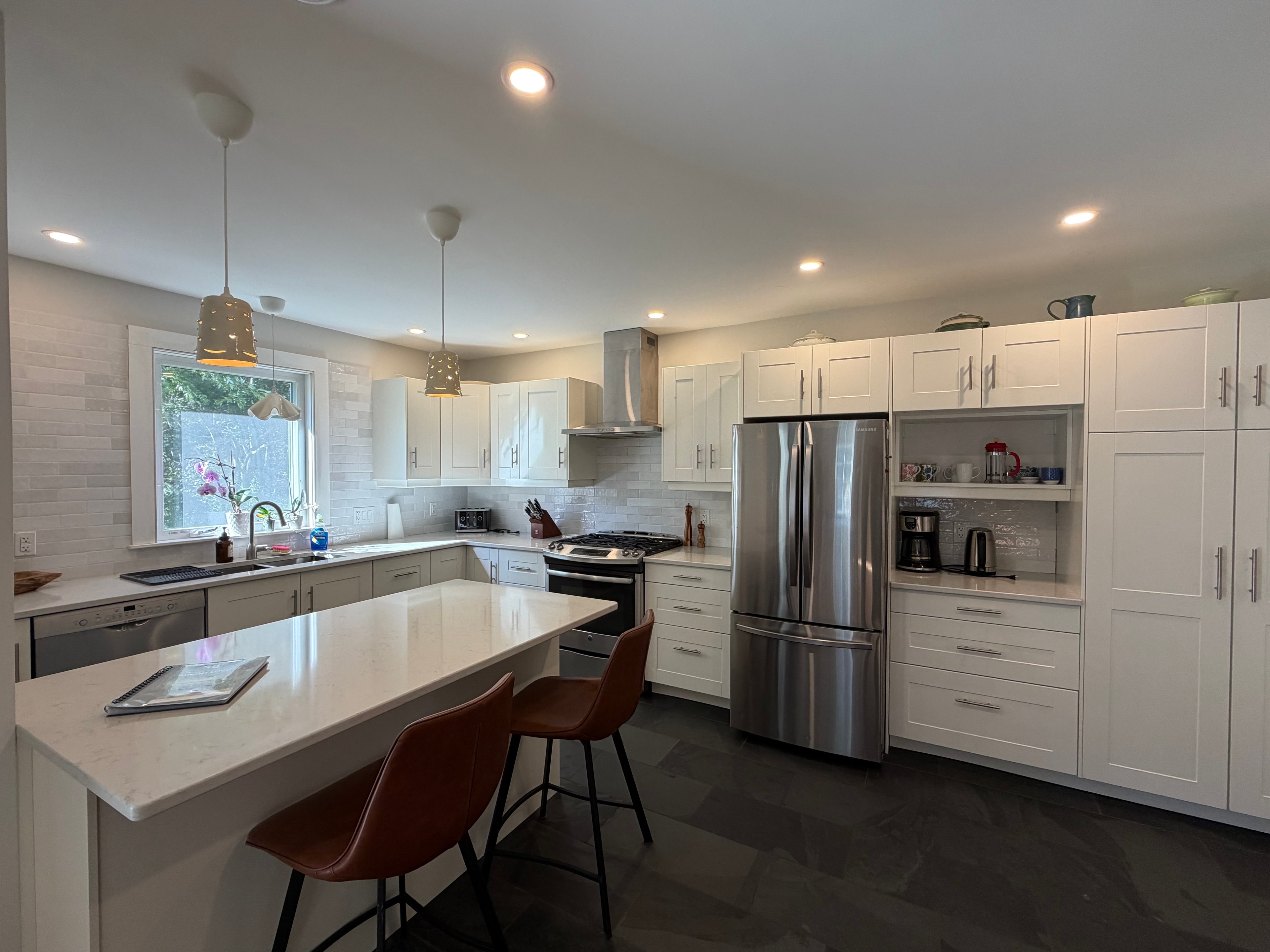 Renovated kitchen — white shaker cabinets, quartz island, stainless appliances