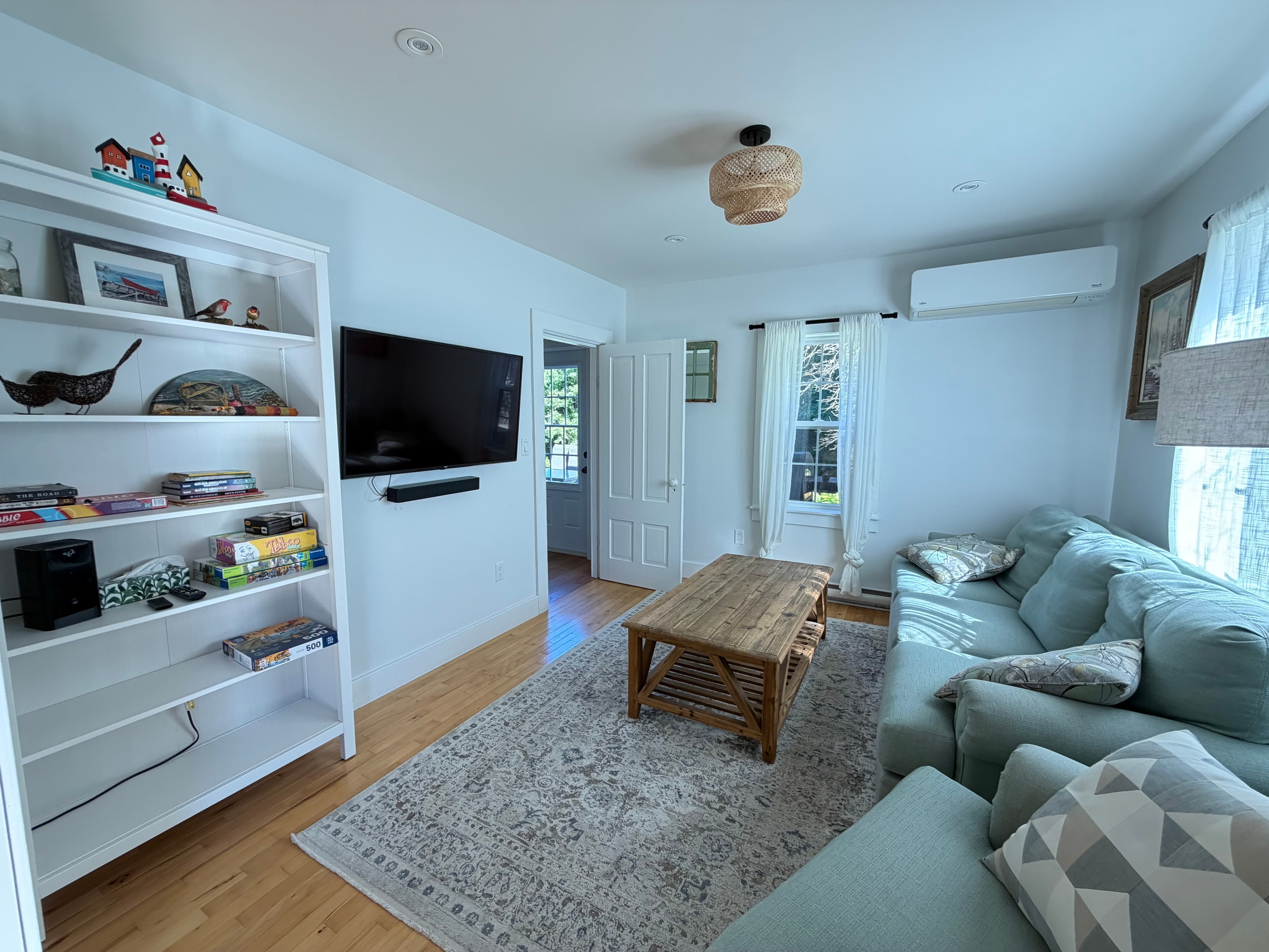 Renovated living room with built-in shelving and hardwood floors